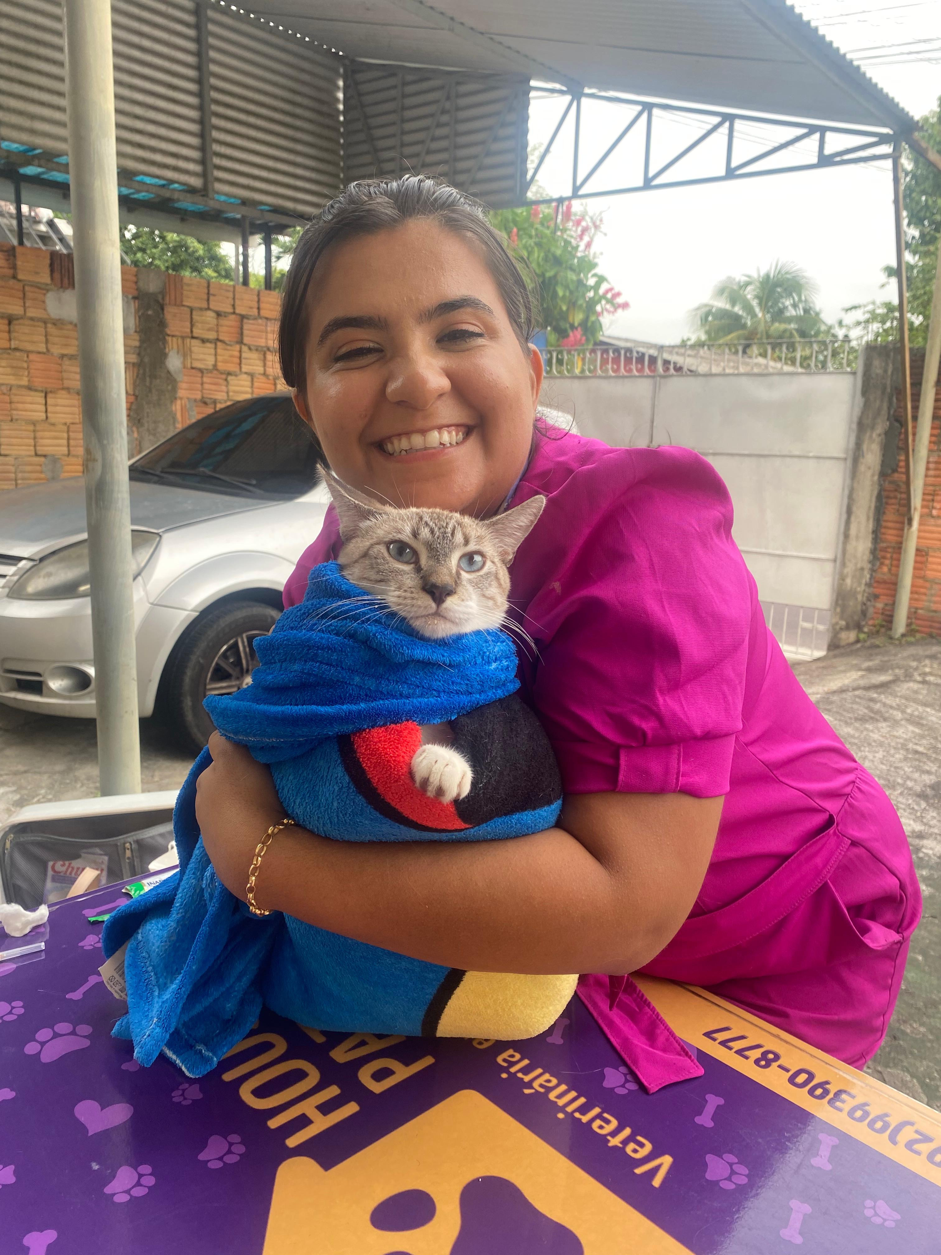 Veterinária da House Patas abraçando gato cinza após procedimento bem-sucedido